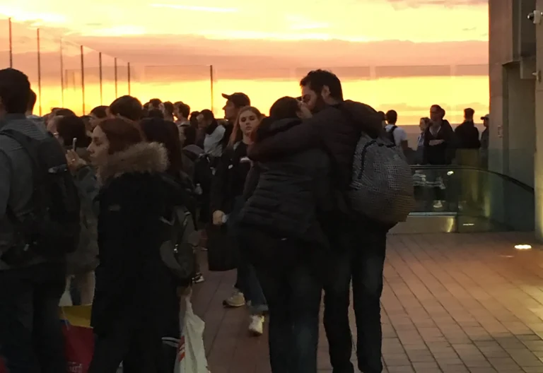 Coppia che cammina abbracciata dopo la proposta di matrimonio al tramonto con vista su New York