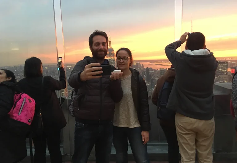 Coppia con anello di fidanzamento davanti allo skyline di New York al tramonto