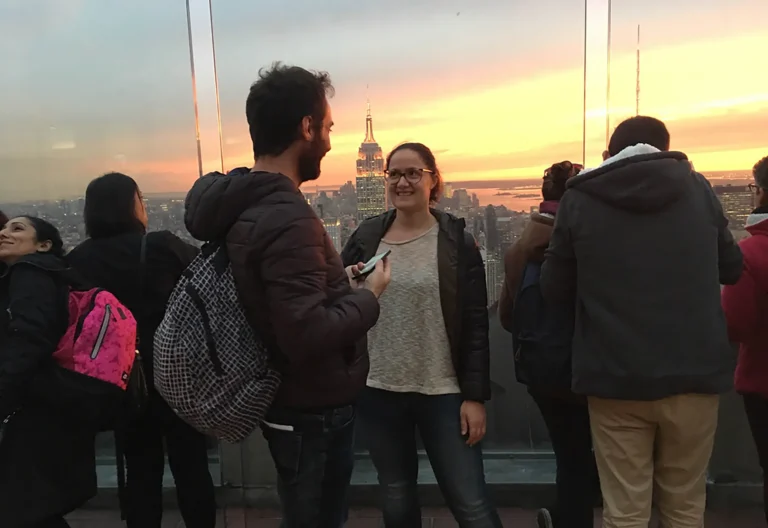 Coppia dopo la proposta di matrimonio a New York con skyline al tramonto sullo sfondo