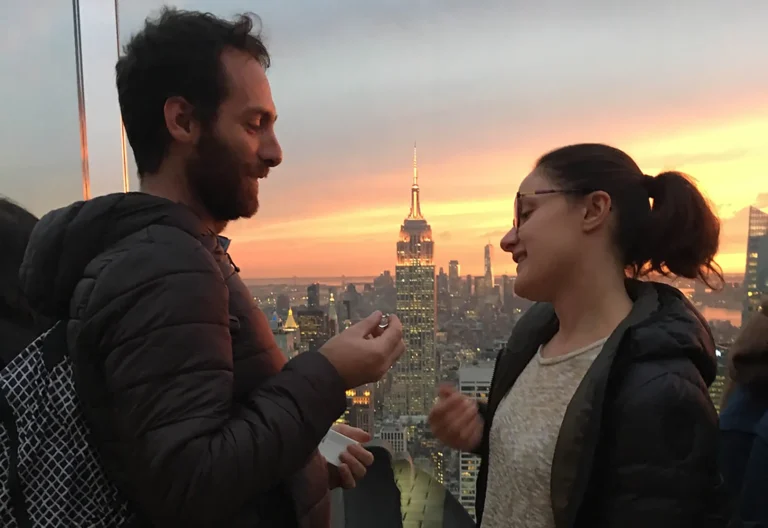 Coppia dopo la proposta di matrimonio con skyline di New York al tramonto