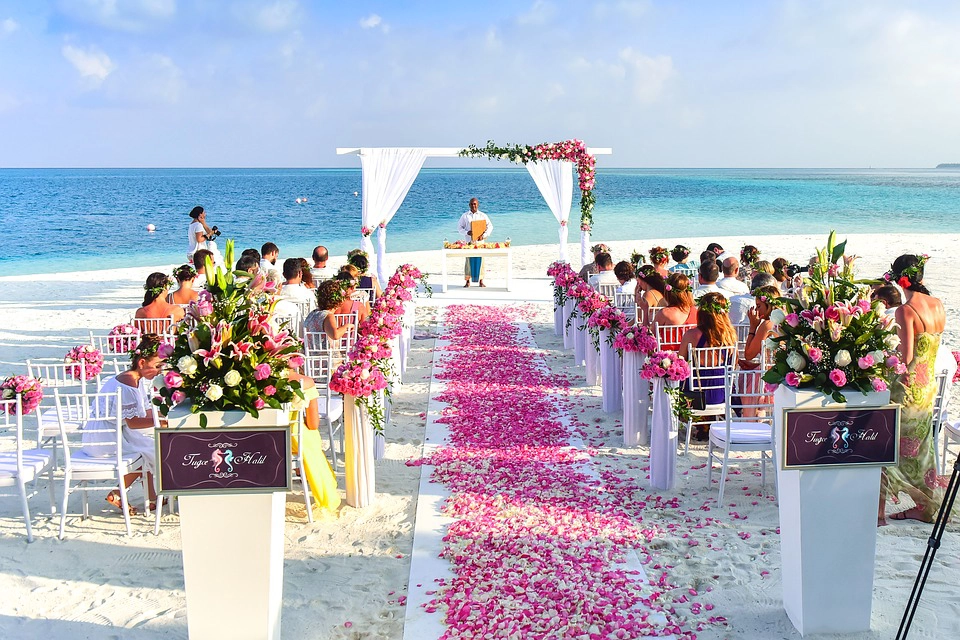 Cerimonia di matrimonio sulla spiaggia con allestimento floreale per un rito simbolico all'aperto