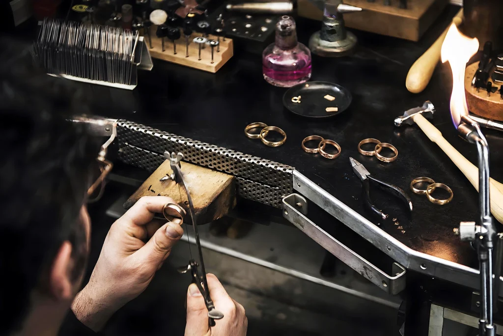 Bespoke wedding rings being crafted at the goldsmith's bench