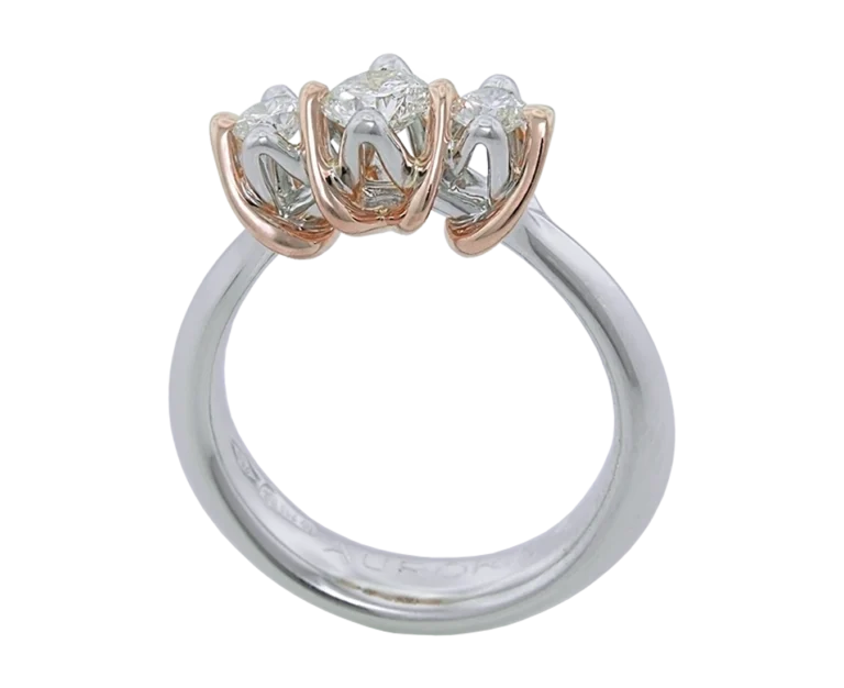 Side view of the Natività ring with a two-tone structure and three diamonds
