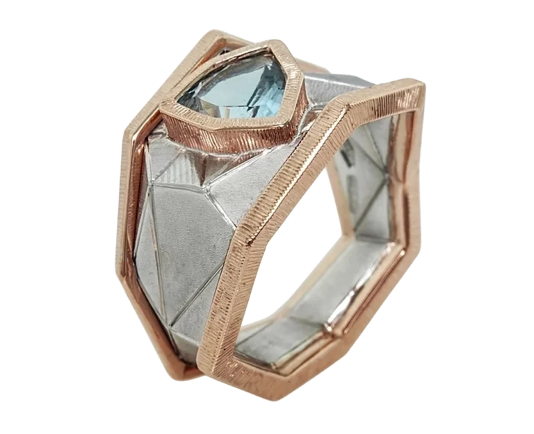 Abstract ring in white gold and rose gold with a trillion-cut aquamarine, three-quarters side view