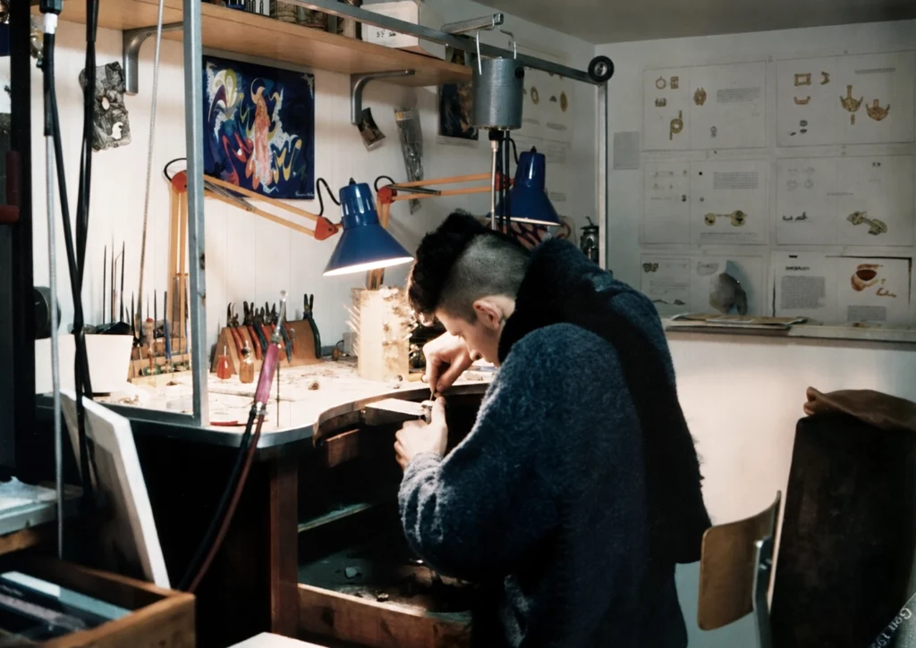 Ragazzo al banco da lavoro in un laboratorio orafo, simbolo della nascita della passione per l'oreficeria e dell'apprendimento artigianale.