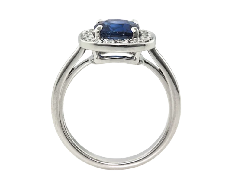 Side view of the claw-set cushion sapphire ring with an open basket