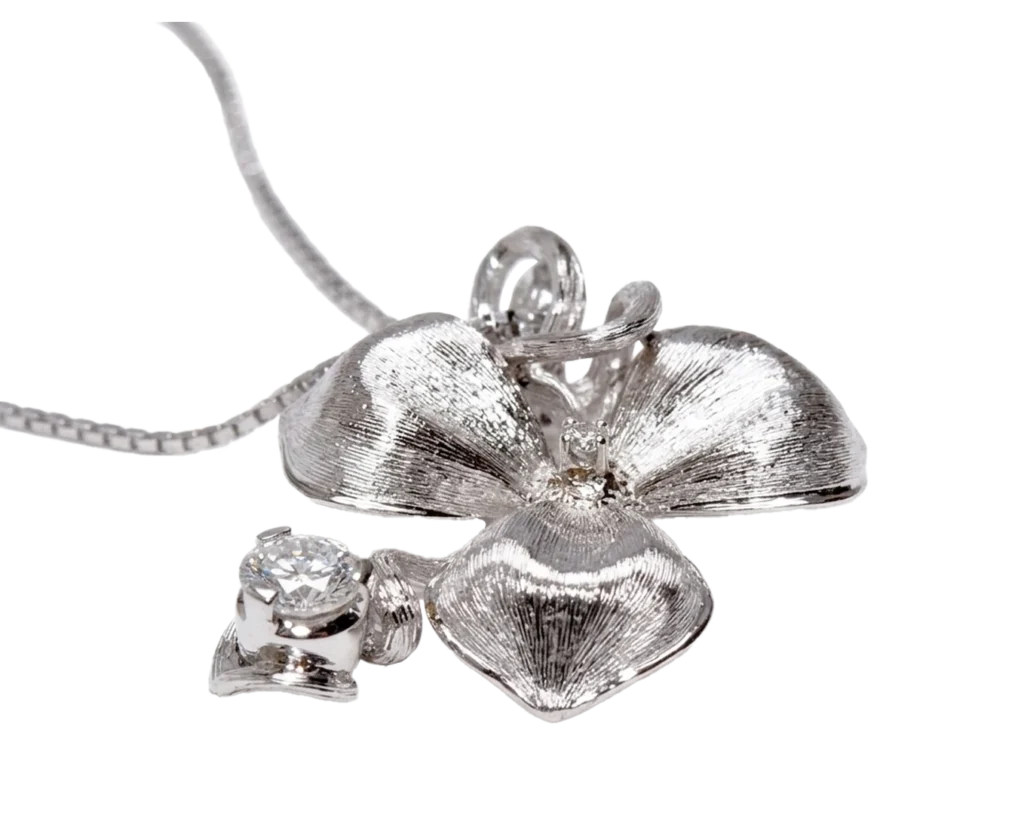 Detail of the white gold Orchid pendant with engraved petals and diamonds