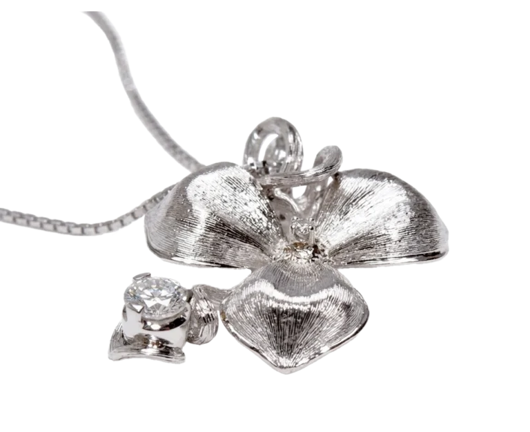 Detail of the white gold Orchid pendant with engraved petals and diamonds